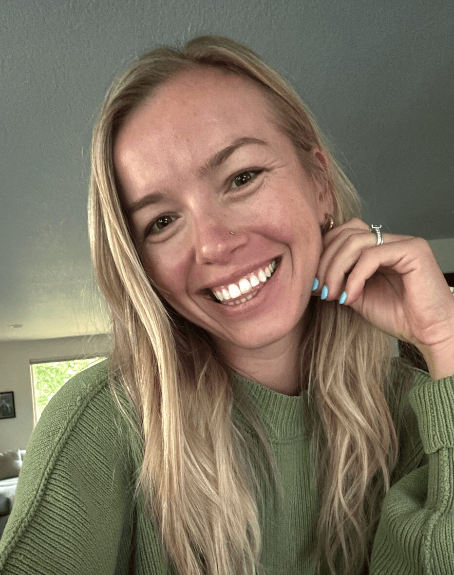 Woman smiling wearing a green sweater close up.